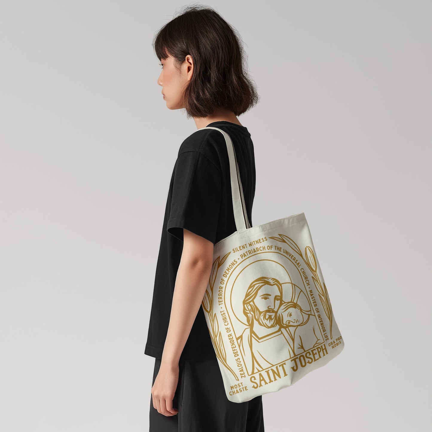 Person wearing a tote bag with 'Saint Joseph' design on a plain background